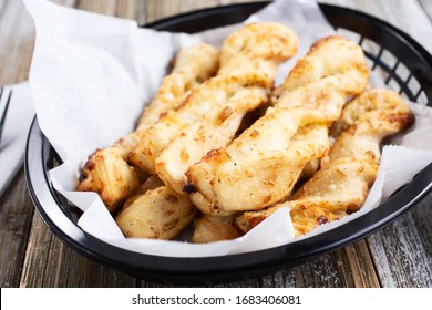 A Closeup Look Of A Basket Full Of Breadstick Twists, In A Restaurant Or Kitchen Setting.