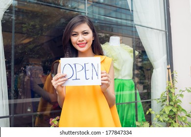 Close-up of a lovely shopkeeper opening up the shop on the foreground  - Powered by Shutterstock