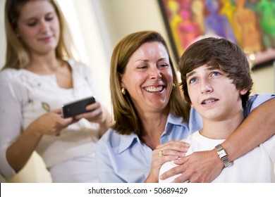 Closeup Of Loving Mother With Arm Around Teenage Son Smiling