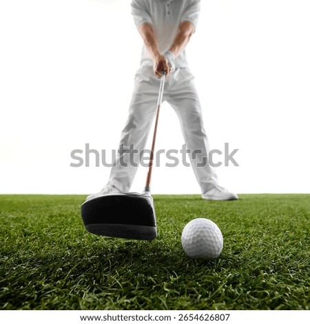 Close-up, low angle view of man preparing to hit ball, with club head and ball in sharp focus on green grass. Concept of golf, luxury, game start, power, timing, sport intensity