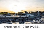 Close-up low angle view of a pile of rubble of a brick wall on the ground that was demolished from an old building with the early morning sun rising in the background in the Thai countryside.