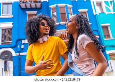 Close-up low angle view portrait of a cool african couple laughing talking in a colorful street - Powered by Shutterstock