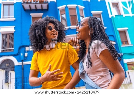 Close-up low angle view portrait of a cool african couple laughing talking in a colorful street