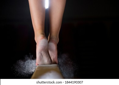 Close-up low section of a female gymnast on balance beam against a black background. - Powered by Shutterstock