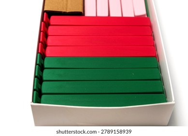 close-up, low-angle perspective looking inside a white cardboard box filled with rows of plastic bag sealing clips