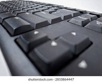 A close-up, low-angle perspective view of a black computer keyboard, highlighting the Enter and Shift keys with a shallow depth of field