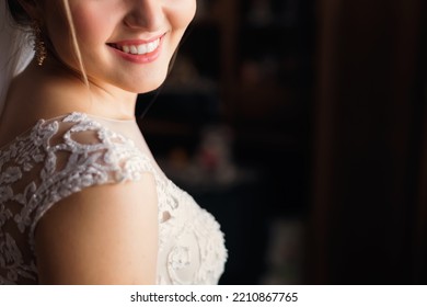 Close-up Of Lower Half Of Face Of The Bride With A Smile. Blurred Background.