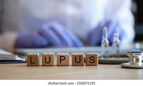 Close-up Of Lupus Word On Wooden Cubes In Raw. Doctor Writing Prescription Or Treatment. Healthcare And Inflammation Of Skin Diseases Concept