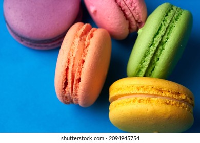 Close-up of macarons cakes of different colors in blue background. Culinary and cooking concept. Tasty colourful macaroons. - Shutterstock ID 2094945754