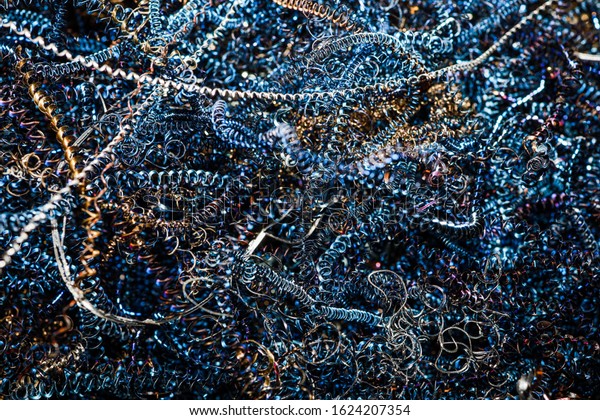 closeup machine blue scrap steel twisted spiral\
steel in tank shavings\
industry