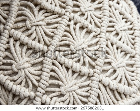 Closeup of macrame pattern with woven ropes. Handmade textile craft, bohemian decor and creative fiber art.
