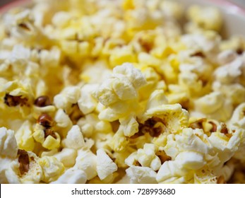 Close-up Macro Detail Of A Bowl Of Freshly Popped Kernels Of Popcorn Yellow From With Movie Theater Butter, From A Top Down Perspective. Foods And Snacks Concept.