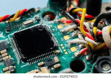 Close-up macro of drone flight controller microprocessor with broken wire. Microelectronics repair.