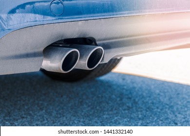 Closeup Macro Of Dual Double Exhaust Pipe. Detail Of Stylish Blue Car Exterior. Sun Flare Leak Light And Copyspace For Text. 