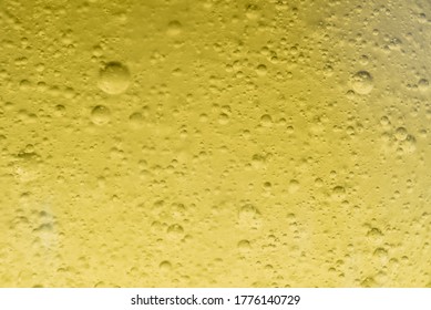 Close-up macro fullscreen with shallow depth of field of bubbles inside a yellow liquid. Graphic design.
