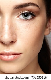 Closeup Macro Portrait Of Female Face. Human Woman Half-face  With Day Beauty Makeup. Girl With Perfect Skin And Freckles.