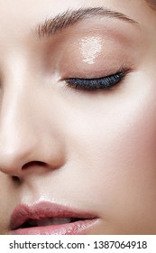 Closeup Macro Shot Of Female Face And Eyes Beauty Makeup. Woman With Glossy Glitter White Skin.