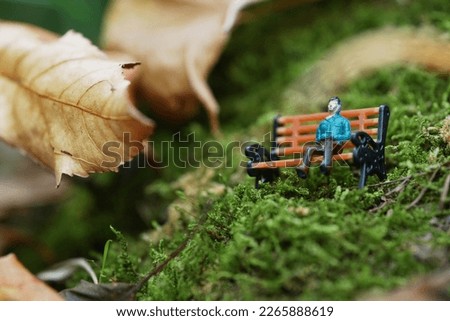                 Closeup and macro shot of miniature people greenery background.                