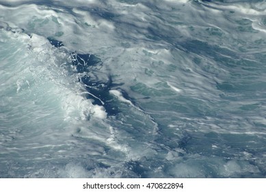Closeup / Macro of spray, splashes, ripples and rough froth on the water surface of the atlantic - single foam crest formation