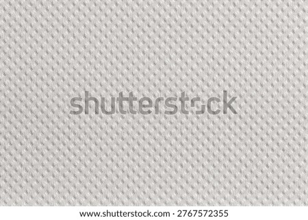 Close-up macro texture of white kitchen paper towel with a regular fine dot embossed pattern. Soft surface with subtle relief, ideal for backgrounds and design projects.