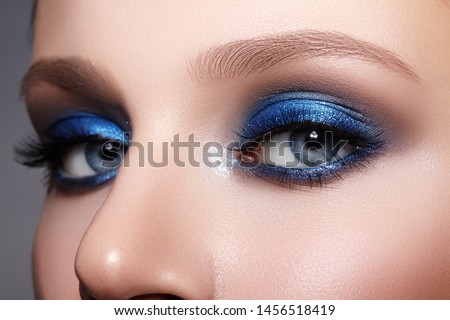 Closeup Macro of Woman Face with Blue Eyes Make-up. Fashion Celebrate Makeup, Glowy Clean Skin, perfect Shapes of Brows. Shiny Simmer and Rouge