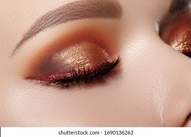 Closeup Macro of Woman Face with Gold glitter Eyes Make-up, bright red liner. Fashion Celebrate Makeup, Glowy Clean Skin, perfect Shapes of Brows. Shiny Simmer and metalic eye shadows