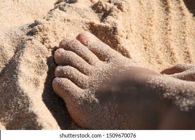 close-up made at the beach of girl's foot in yellow sea sand