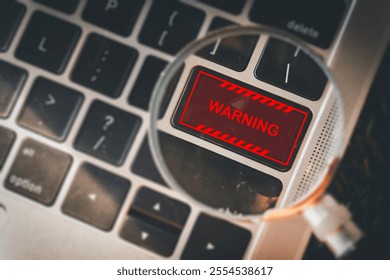 Close-up of a magnifying glass highlighting a warning sign on a laptop keyboard idea for cybersecurity, data protection,IT security,digital safety, system alerts. - Powered by Shutterstock