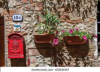 Close-up Of Mailbox Of The Post Office And Flower Pots In Colle Di Val D'Elsa. A Graceful Village With Its Historic Center Preserved And Known By Its Crystal Production. Located In The Tuscany Region 