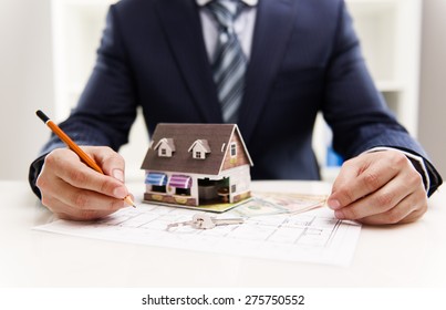 Closeup Of Male Architect Drawing Heating System Plan Of Customer House In The Office. Real Estate Value And Cost Concept.  Shallow Depth Of Field.