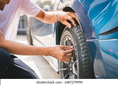 Closeup Male Automotive Technician Removing Tire Valve Nitrogen Cap For Tire Inflation Service At Garage Or Gas Station. Car Annual Maintenance And Repair Concept. Safety Road Trip And Travel Theme.