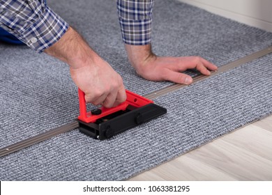 Close-up Of A Male Carpet's Hand Fitter Installing Carpet With Tool