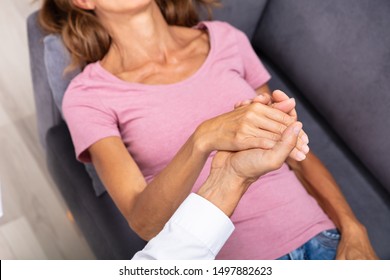 Close-up Of Male Councilor Holding Woman Hand During Hypnotherapy