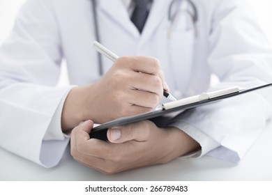 Close-up Of Male Doctor Filling The Medical Form