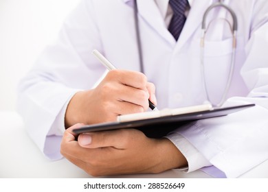 Close-up Of Male Doctor Filling The Medical Form