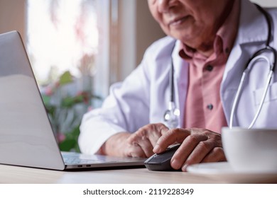 Closeup Male Doctor Hand Using Wireless Mouse, Browsing Medical Information On Laptop Computer With Stethoscope On The Desk. Online Internet Prescription Concept. 