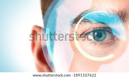 Close-up of male eye with HUD display. Concepts of augmented reality and biometric iris recognition or visual acuity check-up