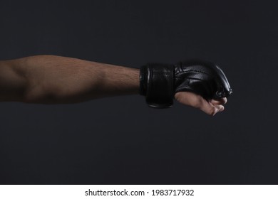Close-up male fighter hand with MMA glove. Fighter clenched fist before a fight or training in a sports gym