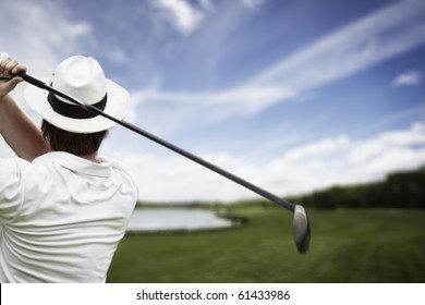 Close-up Of Male Golf Player With Hat Teeing-off At Beautiful Golf Course.