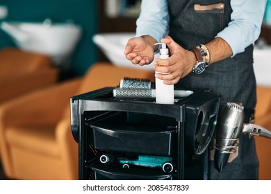 Close-up Of Male Hairstylist Disinfecting His Hands At Hair Salon. 