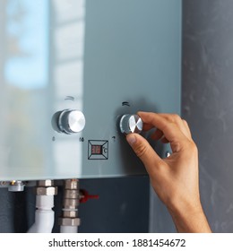 Close-up Of Male Hand Adjusting Temperature Of Water Heater. Modern Home Gas Fired Boiler.