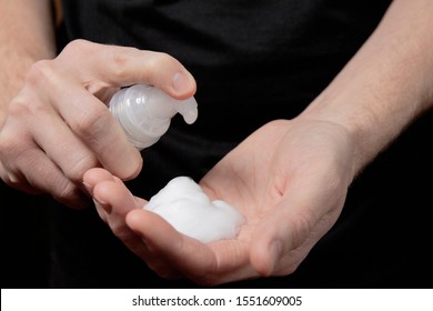 Closeup Of A Male Hand With Foam On The Palm. Man Squeezes Shaving Foam Onto His Hand. Putting Whip Foam Soap Bottle With Foam On Man Hand