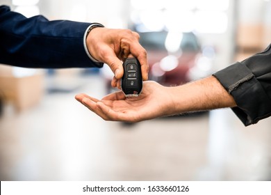 Closeup Of A Male Hand Giving A Car Key Fob To A Worker