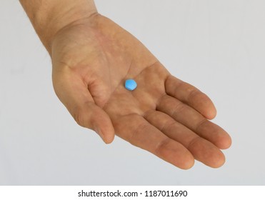 Close-up Male Hand Holding Pill For Sexual Impotence. Medication. Viagra Generic Blue Pill. White Background.