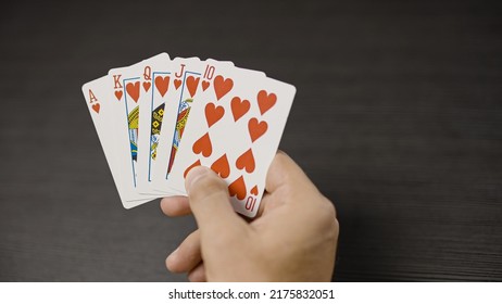 Close-up Of Male Hand Holding Royal Flush Poker Card Combination, Lucky Player