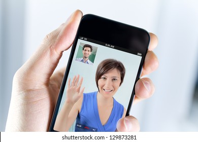 Closeup Of A Male Hand Holding A Smartphone During A Skype Video Call With His Girlfriend Or Wife