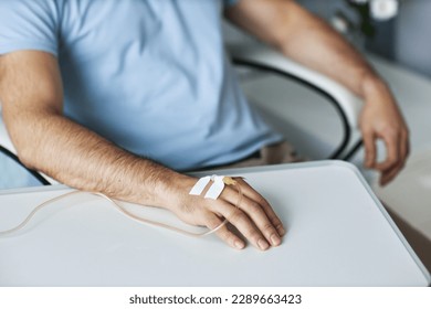 Closeup of male hand with IV drip infusion in treatment session at hospital, copy space - Powered by Shutterstock