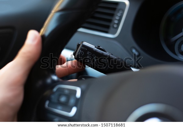 Close-up of male hand, presses signal switch button\
in the car.