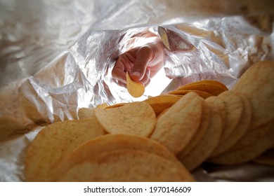 Close-up Of Male Hand Takes Potato Chips From A Bag. Selective Focus.