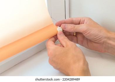 Close-up Male Hands Are Attaching The Details To The Roller Blinds On The Window. Roller Shutter Installation.